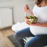 pregnant woman eating salad